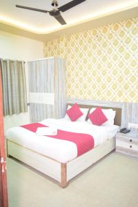 a bedroom with a large bed with red pillows at Vinayak shree hotel in Indore