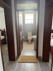 a small bathroom with a toilet and a window at Kaya Homes,Siloam Apartment in Mombasa