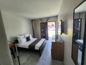 Un dormitorio con una cama, un lavabo y un espejo. en Pine Leaf Apartments, en Lusaka