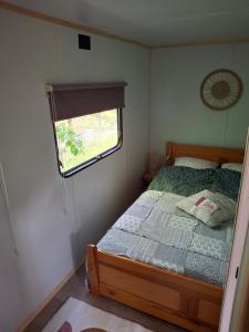 ein kleines Schlafzimmer mit einem Bett und einem Fenster in der Unterkunft Domeczek in Sulęczyno