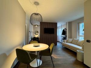 a living room with a table and a couch at VILLAREJA - Private City Suite im Herzen der Bozner Altstadt in Bolzano