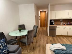 a living room with a table and chairs and a kitchen at FeWo Waldsee mit Pool und Sauna inklusive in Sankt Englmar