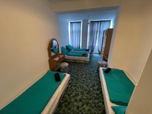 a hotel room with two beds and a couch at Tabán Vendégház in Balatonlelle