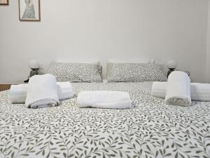 a large bed with white sheets and pillows on it at Be Your Home - Olilà in Civitavecchia