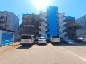 a parking lot with cars parked in front of a building at Premier Elegant Apartments in Harare