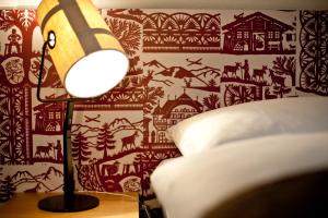 a lamp is lit up on a bed at Hotel Landhaus in Gstaad
