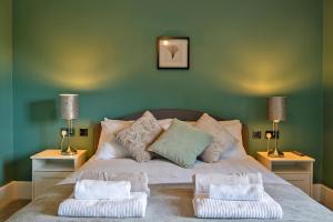 a bed with two pillows on it with two lamps at Knowsley in Bakewell