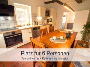 a kitchen with a wooden table in a room at Ferienwohnung im Sauerland Hunde willkommen Kamin und Garten am Waldrand Muehls-Sauerland in Lennestadt