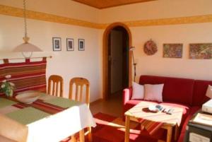 a living room with a red couch and a table at Große Auszeit in Fehmarn
