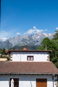 a white house with mountains in the background at La casa de Chachi in Potes