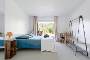 une chambre avec un lit, un bureau et une fenêtre dans l'établissement Maison vue colline au calme avec piscine, à Simiane-Collongue