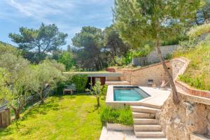 un jardin avec une piscine et une maison dans l'établissement Maison vue colline au calme avec piscine, à Simiane-Collongue