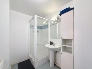 a white bathroom with a shower and a sink at Pleasant Studio in Saint-Brieuc +3 photos