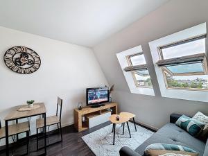 a living room with a couch and a table at Pleasant Studio in Saint-Brieuc