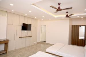 a living room with a couch and a ceiling fan at Radhyam Retreat in Ayodhya