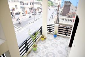 a balcony with potted plants and a city street at Radhyam Retreat in Ayodhya +8 photos
