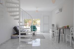 a white room with a staircase and a table and chairs at 2BD Garden Apartment in Paphos