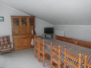 a room with a table and chairs and a television at L'Ortolano Apartments in Spoleto