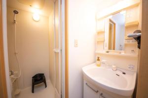 a bathroom with a sink and a mirror and a shower at goom Monthly Nakasu Maxim in Fukuoka +16 photos