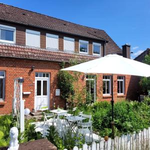 a white umbrella in front of a brick building at Casa Linda in Rotenburg an der Wümme
