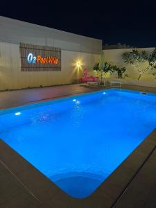 a large blue swimming pool at night at O2 pool villa in Ras al Khaimah +8 photos