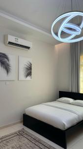 a bedroom with a bed and a chandelier at O2 pool villa in Ras al Khaimah