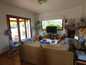 a living room with two couches and a television at Chalet Playa Portonovo in Sanxenxo
