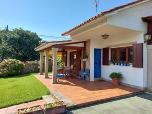 a house with a patio with a blue door at Chalet Playa Portonovo in Sanxenxo