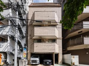 two cars parked in a parking lot in front of a building at Ikebukuro 10 min-Family-Friendly Stay-Mobile Wi-Fi&Switch-Net in Tokyo