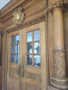 a wooden door with windows and a clock on top at Newnham College - University of Cambridge in Cambridge