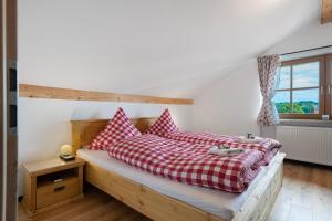 Un dormitorio con una cama con almohadas rojas y blancas. en Ferienwohnung am Teisenberg, en Teisendorf