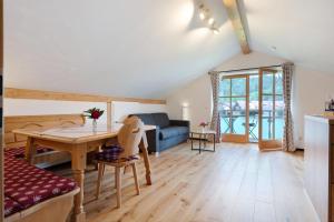 Una sala de estar con un sofá azul y una mesa. en Ferienwohnung am Teisenberg, en Teisendorf