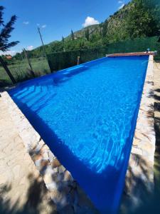 a swimming pool with blue water in a yard at Villa Dalmatina with pool in Kumanovo