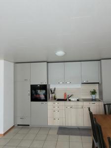 a kitchen with white cabinets and a sink at Appartamento Vacanza 2 locali in Quinto