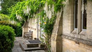 a building with a chair and a window with ivy at The Old Chapel in Painswick