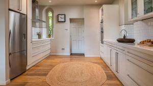 a kitchen with white cabinets and a rug on the floor at The Old Chapel in Painswick +22 photos