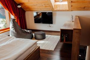a bedroom with a bed and a tv in a room at Apartmán 31 - Villa Erdődy Resort in Oravská Lesná