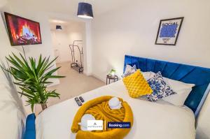 um quarto com um sofá azul e uma cama com um cobertor amarelo em Armoury Square Deluxe 4BR Home near City Centre by AltoLuxoExperience Short Lets & Serviced Accommodation With Free Parking & WiFi em Bristol