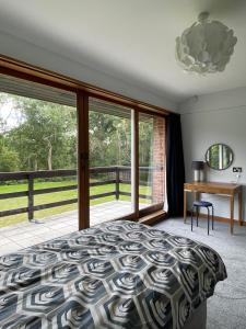 オックスフォードにあるSpacious and stylish with games room, huge garden, peaceful surroundingsのベッドと机と窓のある寝室