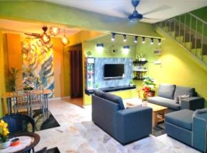 a living room with two couches and a tv at Homestay Rezeki Batu Gajah in Batu Gajah
