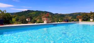 a large swimming pool with a mountain in the background at Casa Stella Country House in Savigno