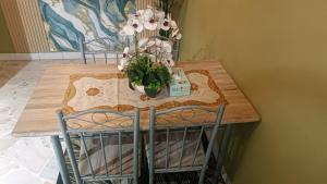 a table with two chairs and a vase of flowers on it at Homestay Rezeki Batu Gajah in Batu Gajah