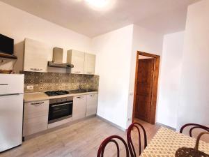 a kitchen with white cabinets and a table with chairs at Casa Roberta in Capoliveri