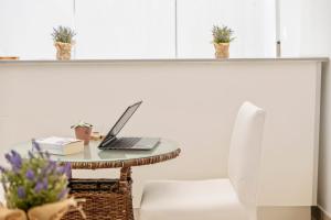 a table with a laptop and a chair at White Waters Hotel in Machico