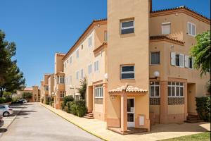 una fila de edificios de apartamentos en una calle en Novo Atlántico Golf, Novo Sanctipetri, en Novo Sancti Petri