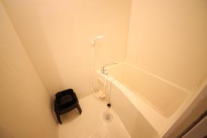 a small bathroom with a urinal and a black stool at goom Hotel Nakasu JOJO in Fukuoka