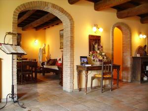Vigarano MainardaにあるHotel Antico Casaleのアーチ道のあるリビングルーム(テーブル、椅子付)