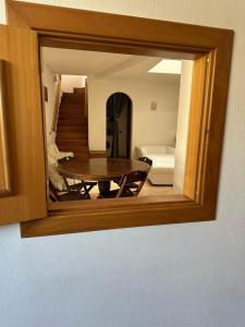 a mirror reflecting a room with a table and a couch at Villa Robienne in Forio d'Ischia