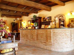 eine Bar in einem Zimmer mit Ziegelwand in der Unterkunft Hotel Antico Casale in Vigarano Mainarda