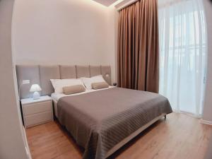 una camera da letto con un letto grande e una grande finestra di Genci's Apartaments a Vlorë